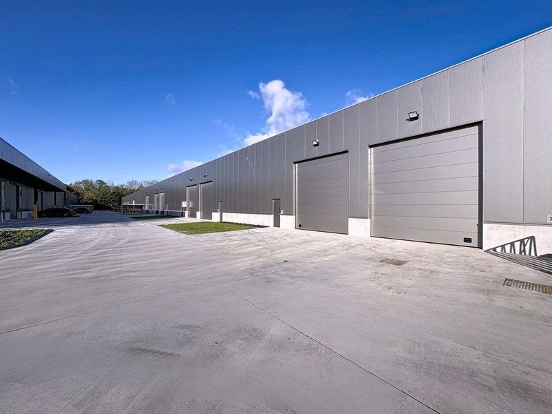 NB KMO-UNIT (214m²) met mezzanine op verdieping, elektrische sectionaalpoort en sanitair blok te huur op industriezone "Herdersbrug" te 8000 Brugge foto {{pictureIndex}}