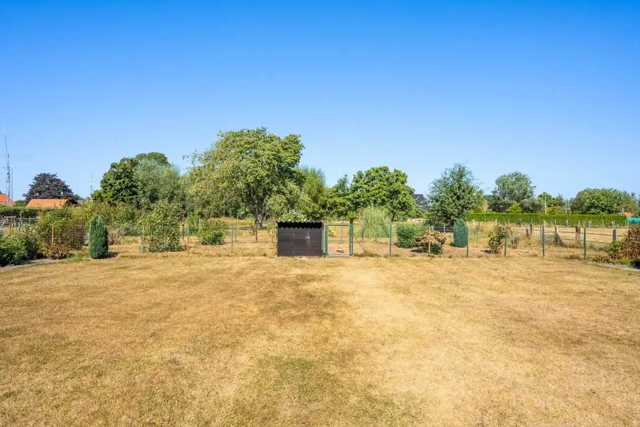 Degelijke te moderniseren open gelijkvloerse woning met inpandige garage én ruime afzonderlijke garage en een grote zonnige tuin in het centrum van Doorslaar! foto 2
