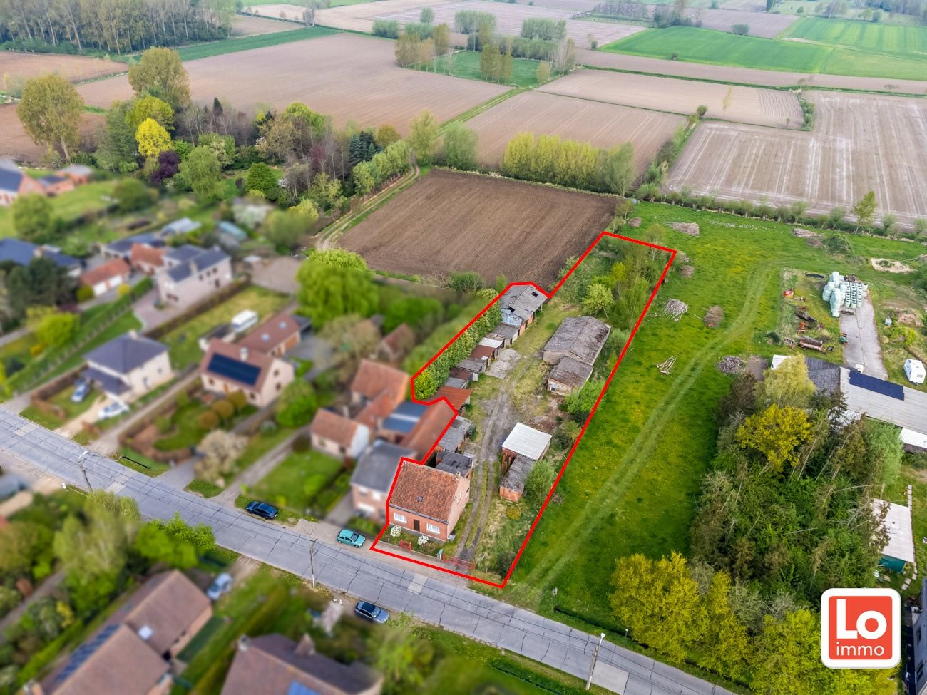 Hoofdfoto van de publicatie: Landelijk gelegen halfopen woning met verschillende stallingen op groot perceel grond met open zicht in Zeveneken!