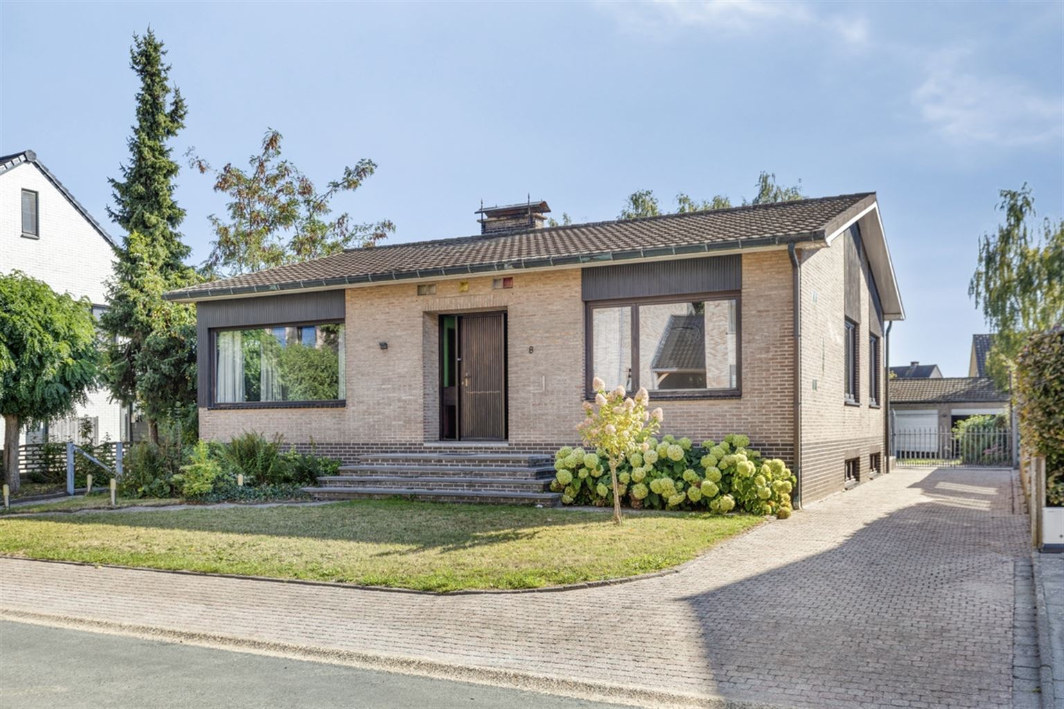 Hoofdfoto van de publicatie: Vrijstaande woning met 3 slaapkamers, ruime tuin en garages op een riant perceel van 9a18ca, rustig gelegen nabij het centrum van Maaseik. 