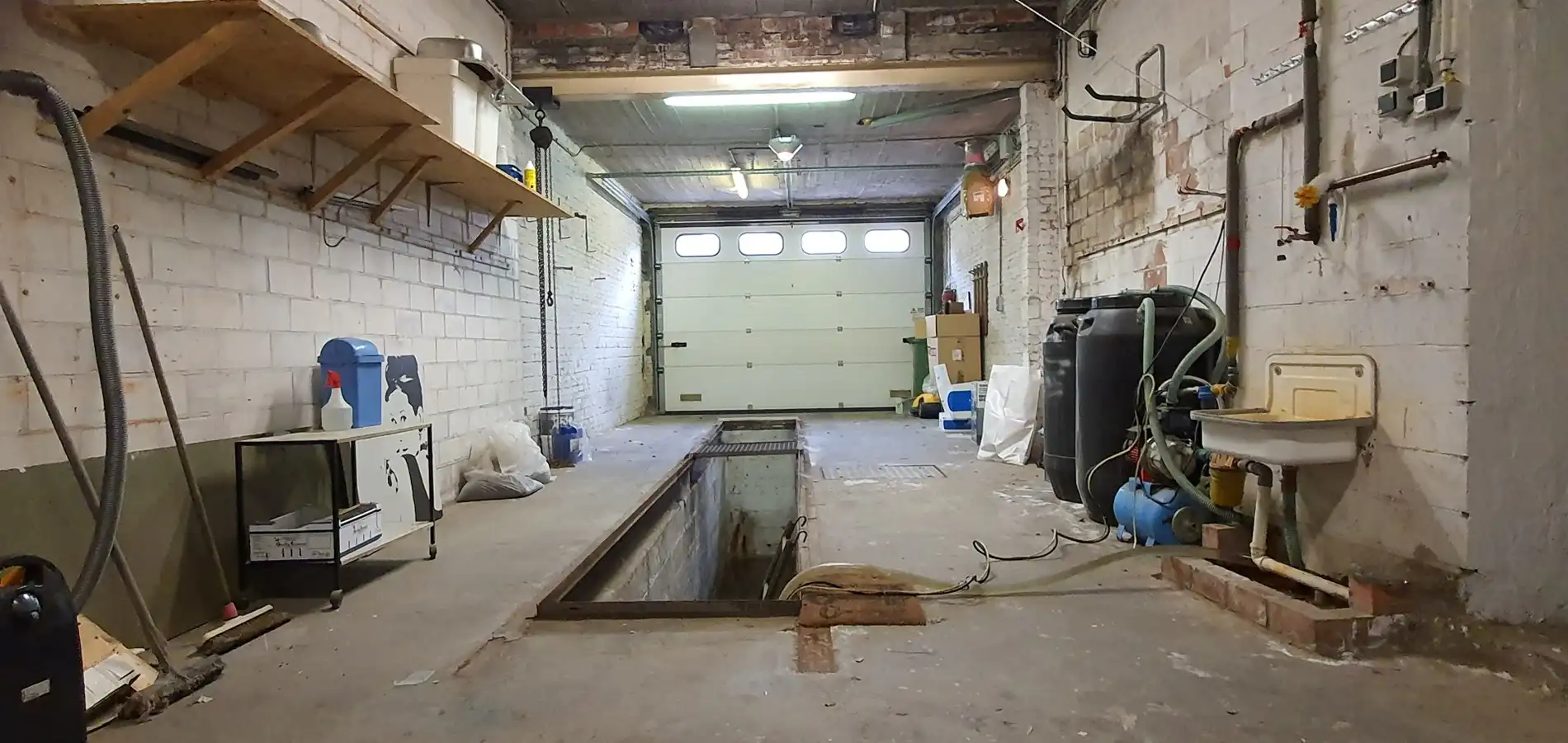 Ruime garage/magazijn met smeerput en elektrische poort foto 7