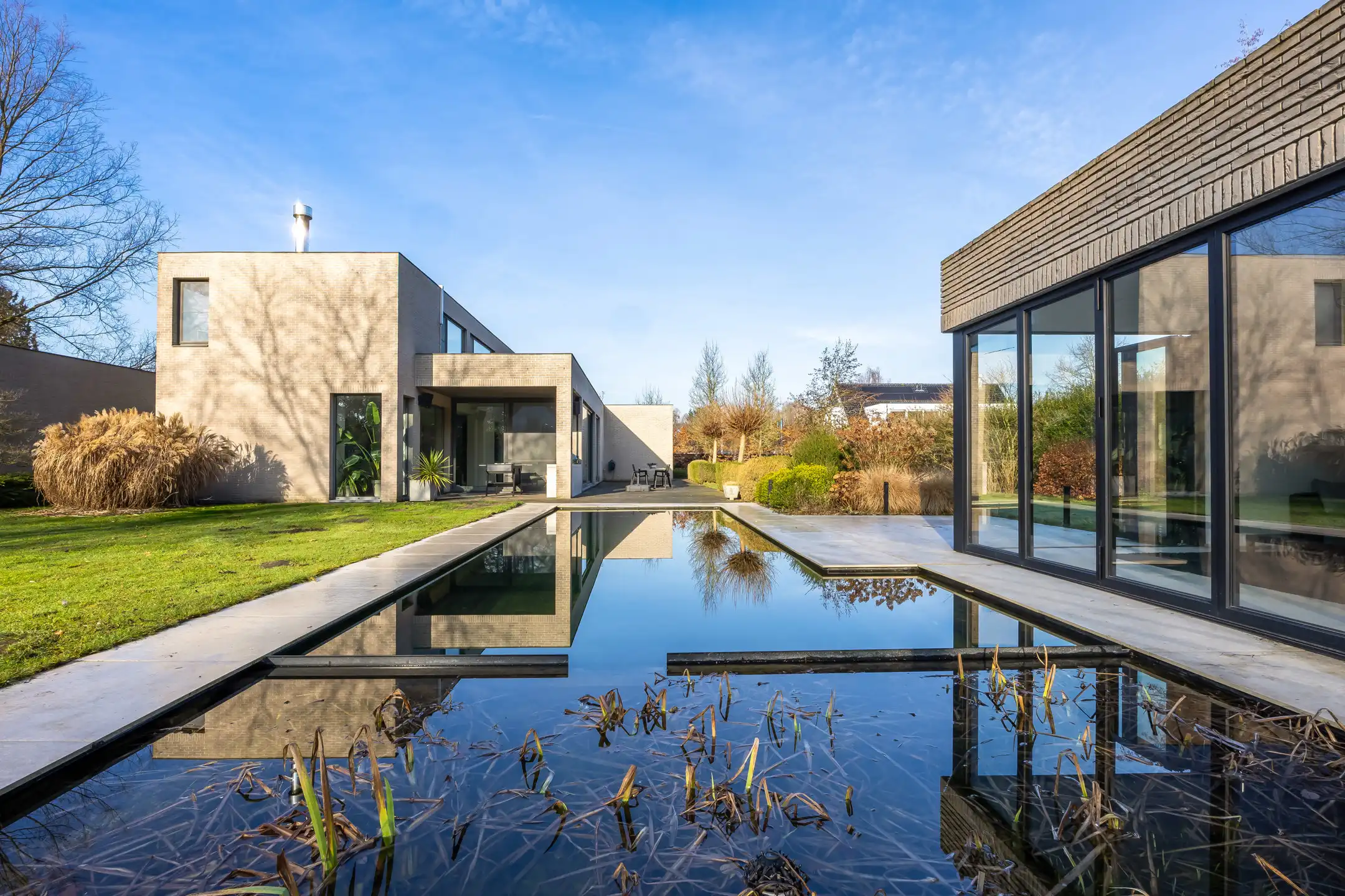 Luxueuze moderne villa met zwemvijver omringd door groen foto {{pictureIndex}}